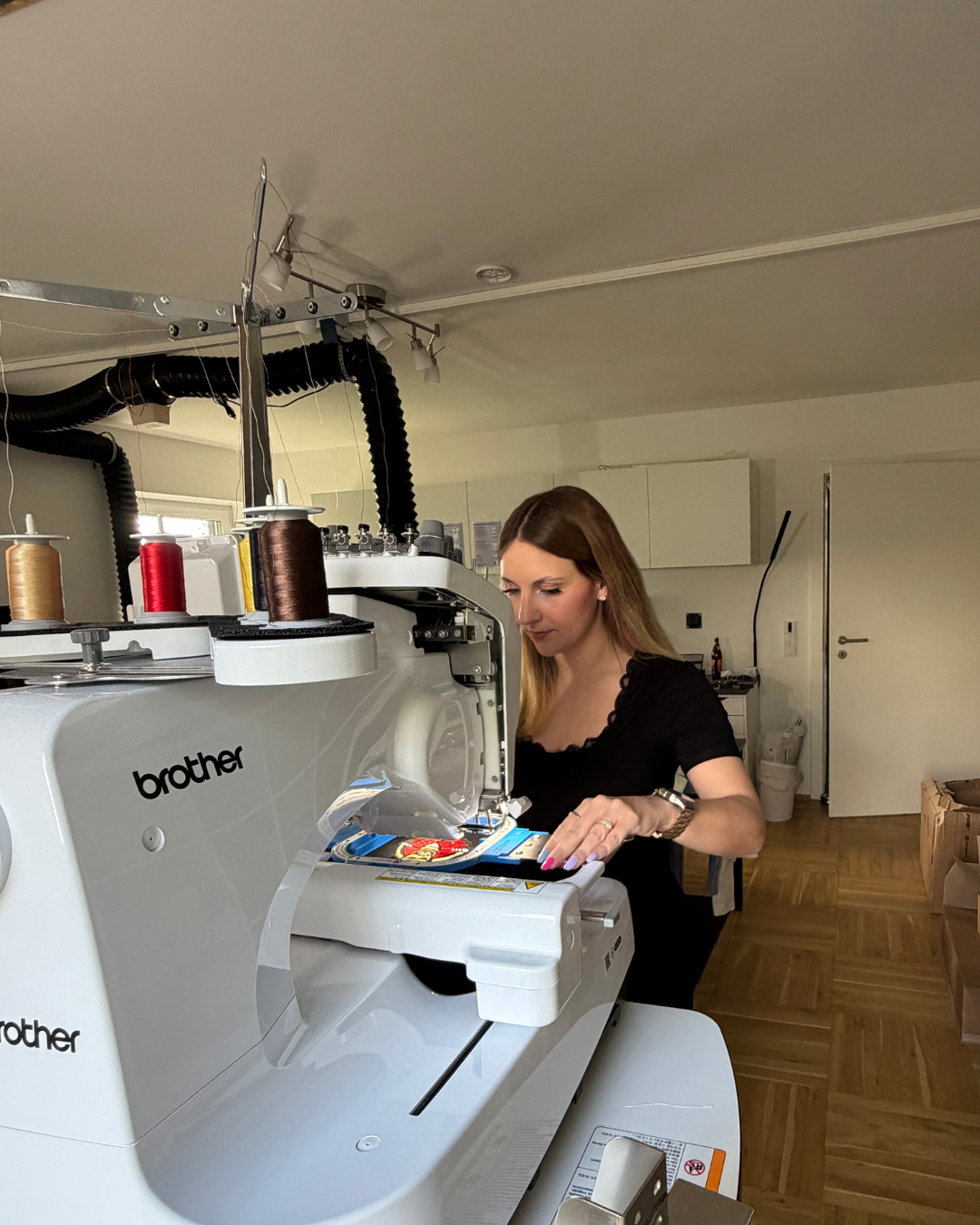 Lara Uschakow working at her Brother embroidery machine in the Textilstätte studio