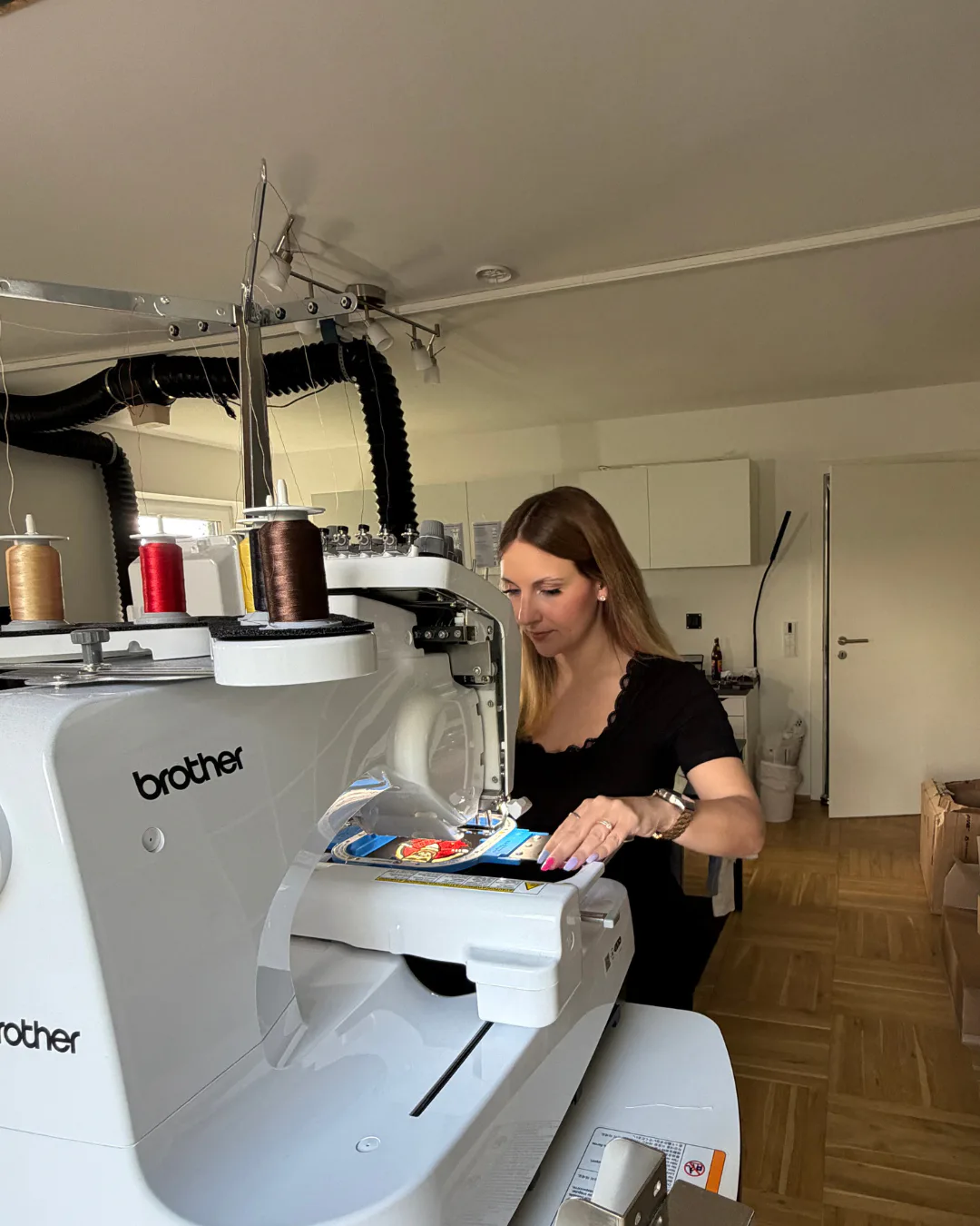 Lara Uschakow working at her Brother embroidery machine in the Textilstätte studio
