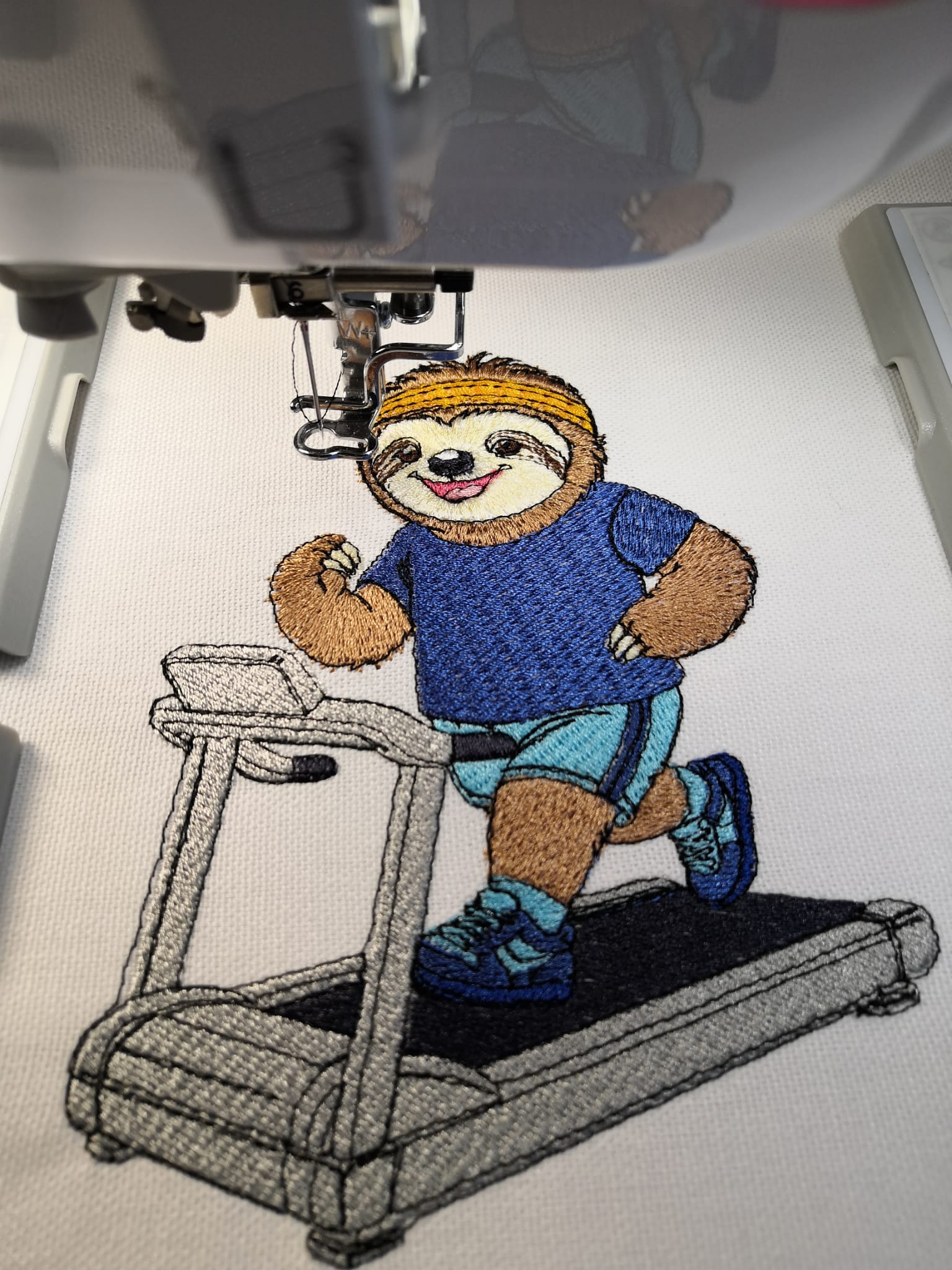 Gesticktes Fitnessfaultier von Atelier RoCas auf einem Laufband mit Stirnband, Sportkleidung und Laufschuhen